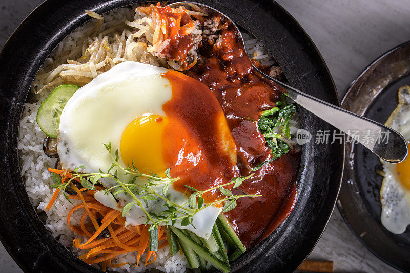 BI Bim Bap，拌菜饭，顶视图与热酱在铸铁锅